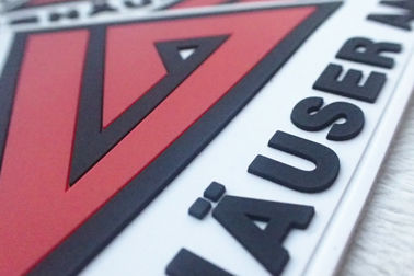 El rojo y el blanco grabaron en relieve insignias del silicio modificaron remiendos de goma suaves del PVC para requisitos particulares de los logotipos