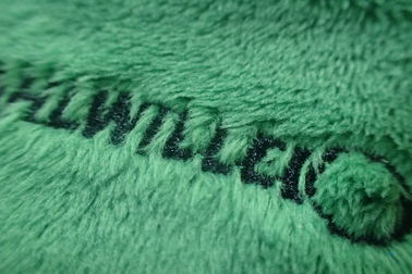 La aduana verde del rectángulo bordó remiendos en la tela del terciopelo para el equipaje