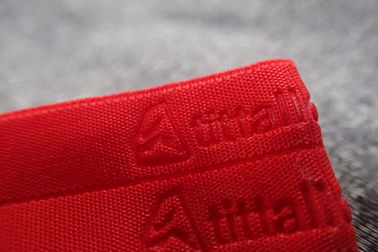 Banda tejida ropa de deportes grabada en relieve rojo