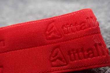 Banda tejida ropa de deportes grabada en relieve rojo