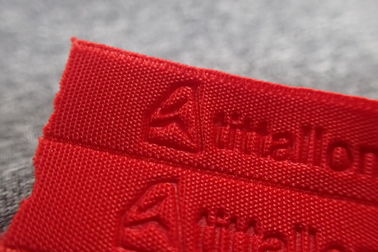 Banda tejida ropa de deportes grabada en relieve rojo