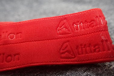 Banda tejida ropa de deportes grabada en relieve rojo