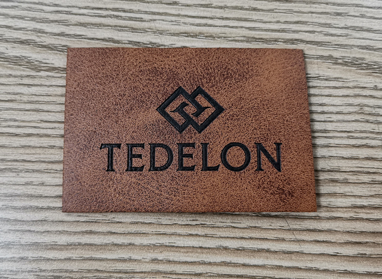 El color de encargo grabado en relieve de las parches de cuero de la PU del logotipo cose en la ropa