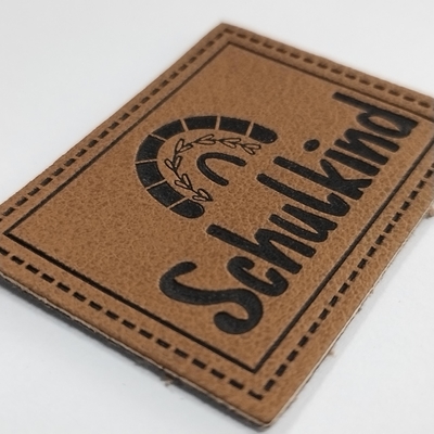 La etiqueta de cuero grabada en relieve microfibra de la PU del logotipo cose en la ropa modifica diseño para requisitos particulares