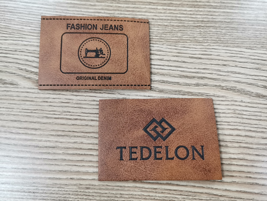El color de encargo grabado en relieve de las parches de cuero de la PU del logotipo cose en la ropa